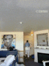a living room with a painting of a man on the wall and the word camera on the ceiling