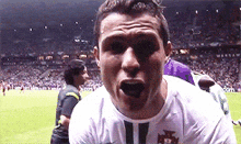 a soccer player is making a funny face in front of a crowd of people