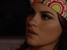 a close up of a woman wearing a colorful head scarf