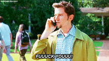 a man in a green jacket is talking on a cell phone and saying fuuuck youuu .