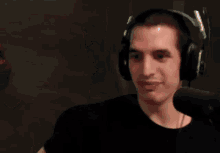 a bald man wearing headphones is talking into a microphone ..