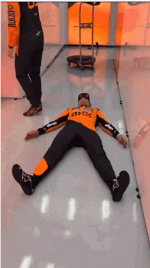 two men are laying on the floor with one wearing a shirt that says bmx
