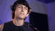 a man singing into a microphone with his eyes closed and his mouth open