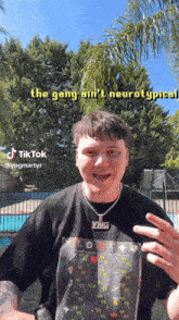 a man wearing a black t-shirt with a ying necklace