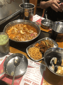 a table with plates of food and a menu that says take away on it