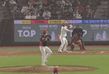 a baseball game is being played in front of a t.o.p. banner