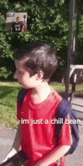 a young boy in a red shirt with a backpack is talking on a video call