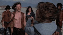 a group of people are standing on a beach and one of them is wearing a hoodie that says ufc