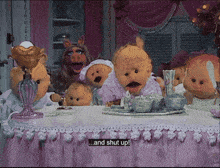 a group of stuffed animals are sitting around a table with a sign that says and shut up