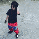 a little boy is standing on a sidewalk with his arms outstretched and the word litty written on the bottom .