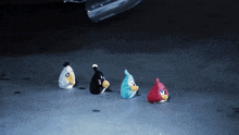 four angry birds are sitting on the ground in a dark room