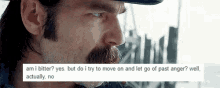 a man with a beard and mustache is wearing a hat and looking at something .