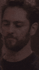 a man with a beard is wearing a blue sweater