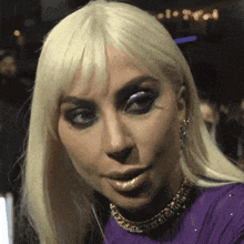a close up of lady gaga 's face with a purple dress
