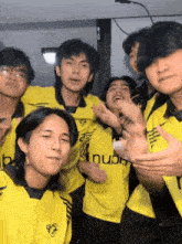a group of young men wearing yellow shirts with the word nubi on the front