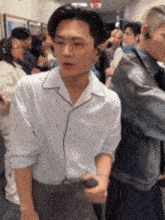 a man in a white shirt is standing in a crowd of people