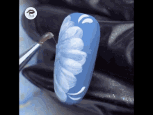 a close up of a nail with a flower painted on it