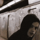 a man in a hooded sweatshirt is walking on a train