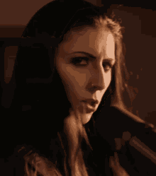 a woman singing into a microphone with a nose piercing