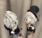 a person is holding two stuffed animals in their hand .