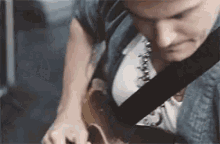 a man is playing a guitar in a room .