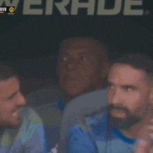 a blurry picture of three men sitting in front of a sign that says verkade