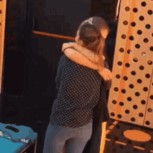 a woman hugging another woman in front of a wall with polka dots