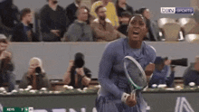 a woman is holding a tennis racquet in front of a crowd with the words bein sports on the bottom