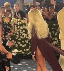 a woman in a high slit dress is dancing in front of a crowd
