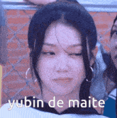 a close up of a woman 's face with the words yubin de maite written on it