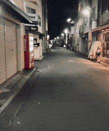 an empty street with a coca cola vending machine on the side