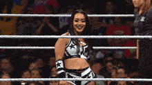 a woman in a wrestling ring with a referee standing behind her