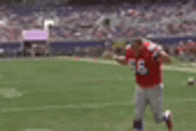 a football player wearing a red jersey with the number 56 on it is running on the field .