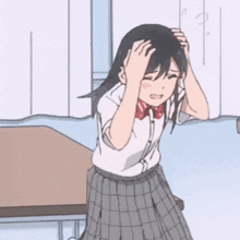 a girl in a school uniform is holding her head while sitting at a desk .