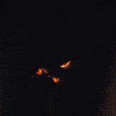 a large fire is burning in the dark with smoke coming out of it