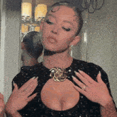 a woman in a black dress with a gold brooch on her chest