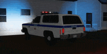 a white police vehicle is parked in front of a white building