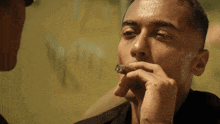 a close up of a man smoking a cigar in front of a mirror
