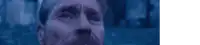 a close up of a man 's face with blue eyes against a dark blue background .