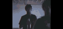 a man in a black shirt is standing next to a woman in a room .