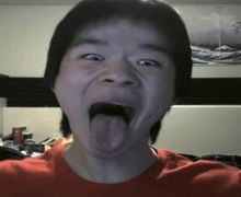 a boy sticking his tongue out in front of a picture