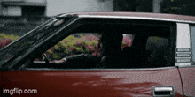 a man is driving a red car with the number 100 on it