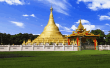 a large gold pagoda is surrounded by a fence