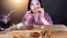 a woman is sitting at a table eating a sandwich