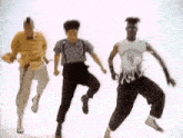 three men are dancing together in a white room