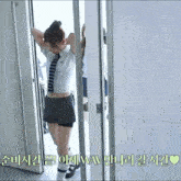 a woman in a striped shirt and tie is standing in a doorway behind bars