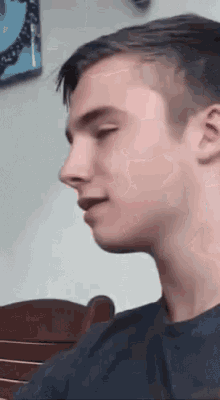 a young man is sitting in a chair with his mouth open and looking at the camera .