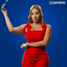 a woman in a red dress holds up a thumbs down sign in front of a blue background that says fox deportes
