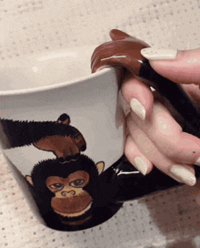 a woman holds a mug with a chimpanzee on it