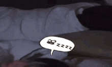 a person is laying on a bed with a speech bubble that says zzz